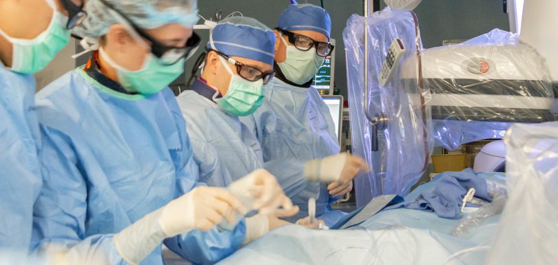 Biplane digital subtraction angiography DSA catheterization suite with neuro-interventional team