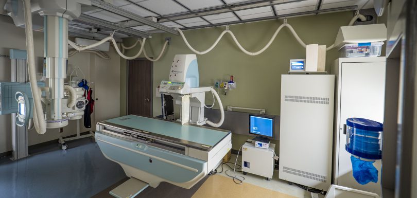Modern digital radiography X-ray suite with ceiling suspension tube and floating table