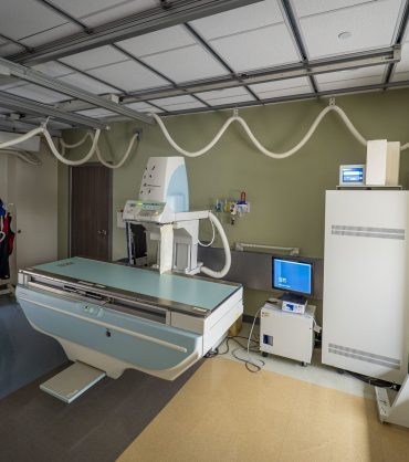 Modern digital radiography X-ray suite with ceiling suspension tube and floating table